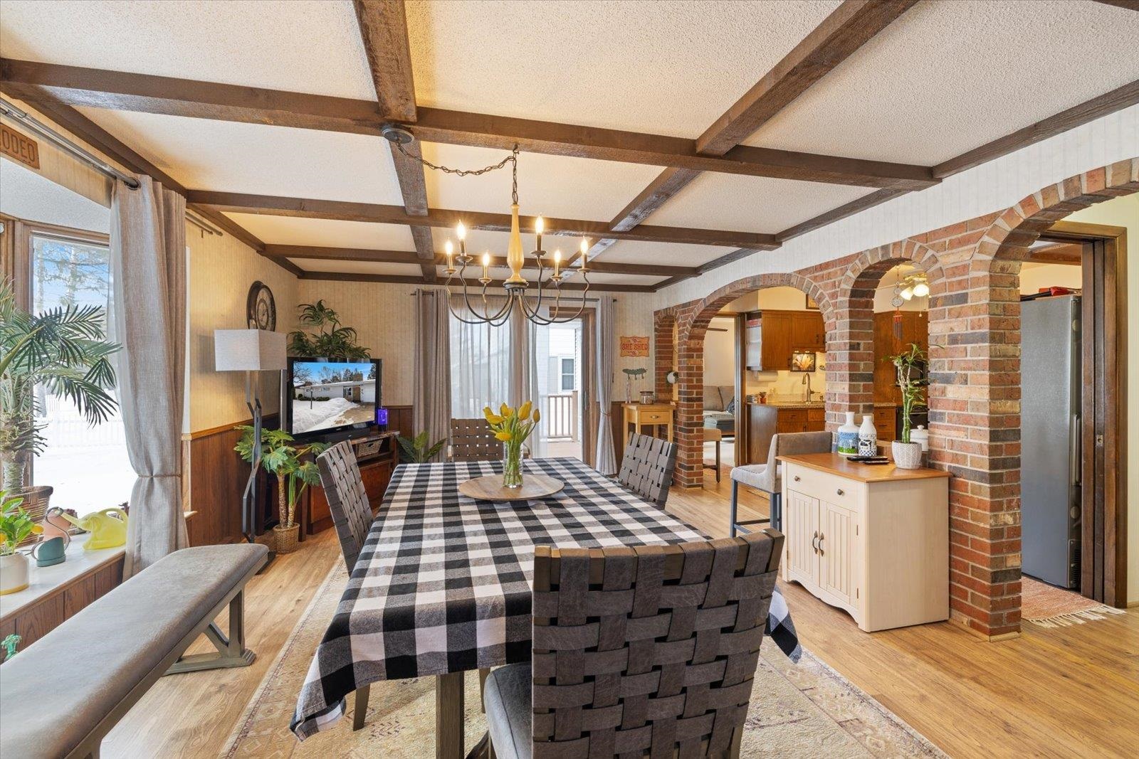 502 North Inner Drive Hibbing, MN 55746 - Photo 22 of 57 Dining area featuring arched walkways, light wood finished floors, a wainscoted wall, suspended lighting, and coffered ceiling