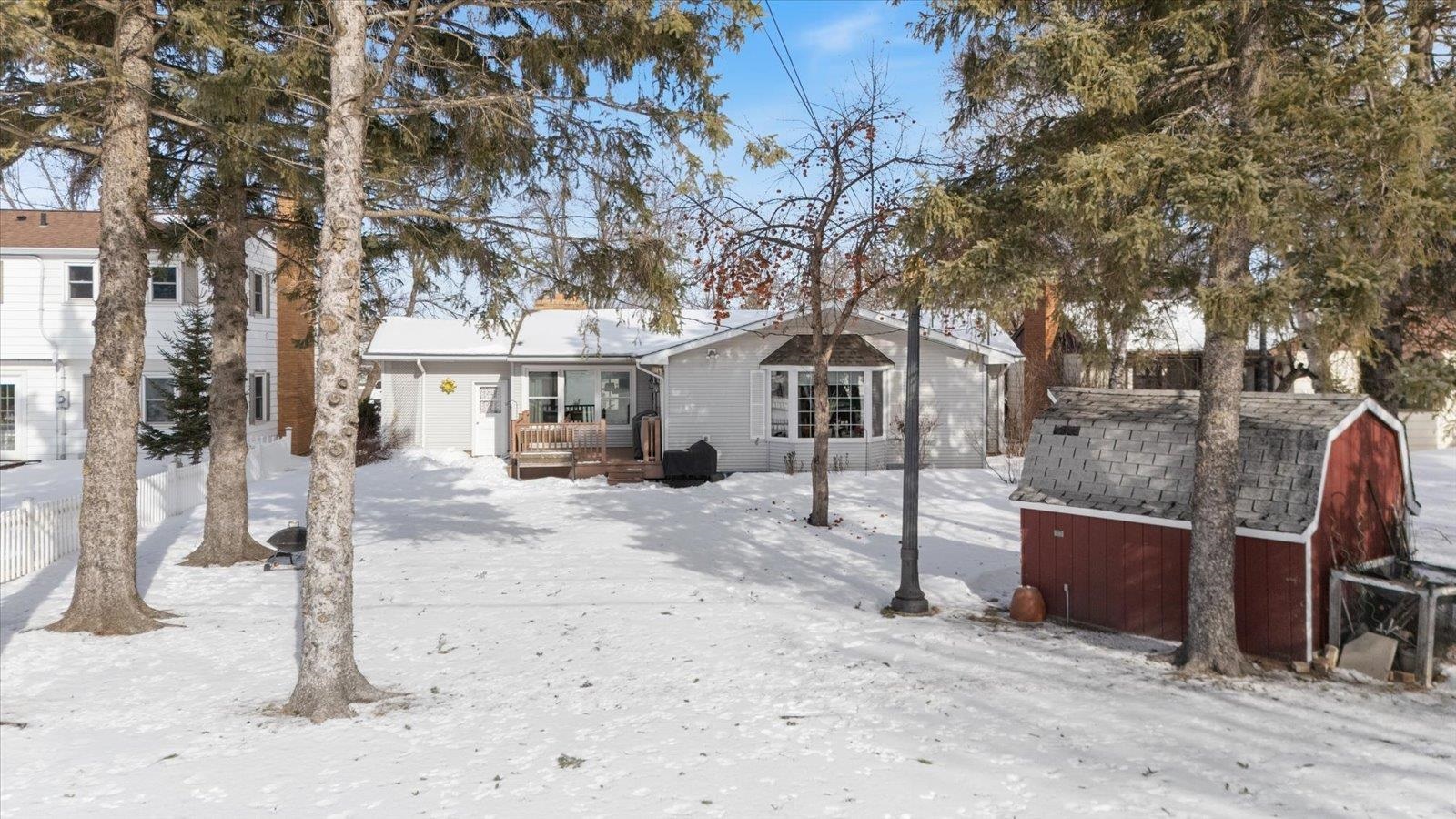 502 North Inner Drive Hibbing, MN 55746 - Photo 8 of 57 Snow covered back of property with a wooden deck and a storage shed