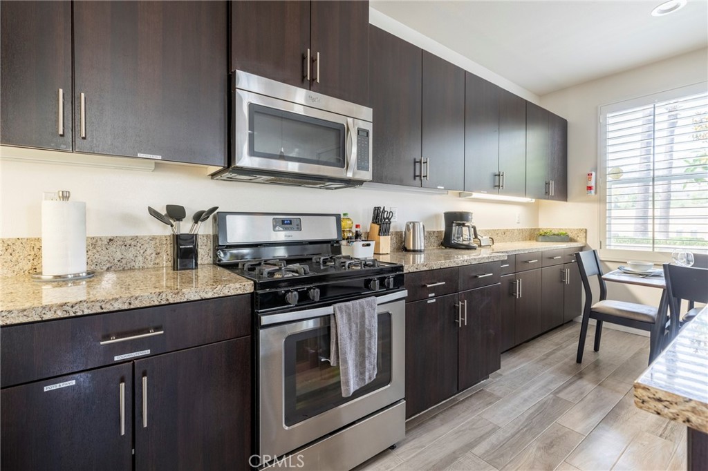 816 East Promenade, Unit A Azusa, CA 91702 - Photo 15 of 75 a kitchen with granite countertop wooden cabinets and a stove top oven