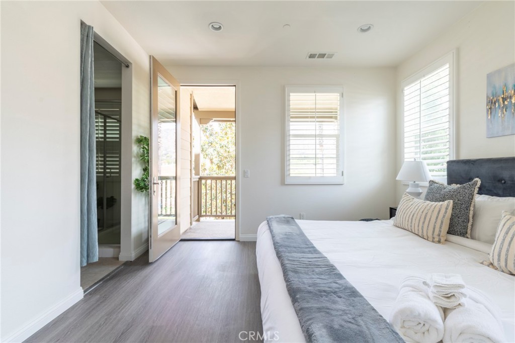 816 East Promenade, Unit A Azusa, CA 91702 - Photo 31 of 75 a bedroom with a large bed and wooden floor