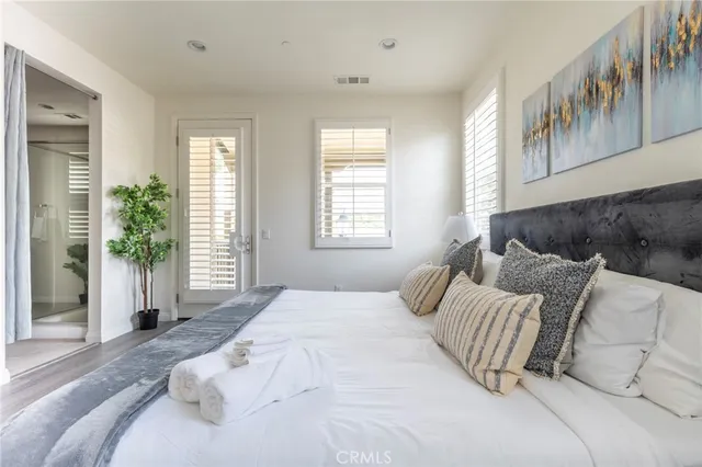 a bed sitting in a bedroom next to a window with lamp