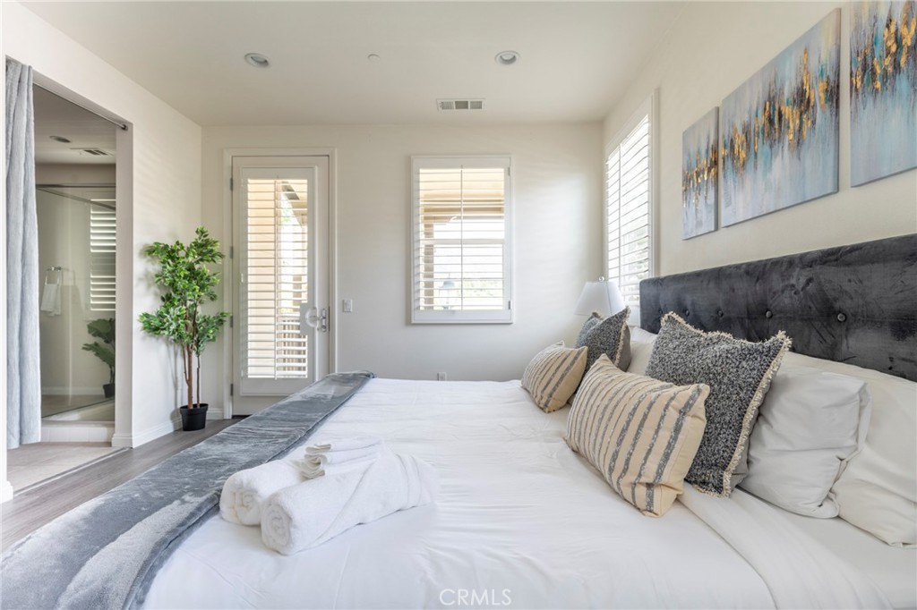 816 East Promenade, Unit A Azusa, CA 91702 - Photo 44 of 75 a large bed sitting in a bedroom next to a window and a chair