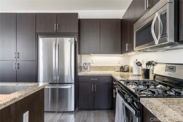 a close view of a stove and a sink with wooden cabinets