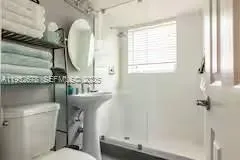 a bathroom with a sink toilet and shower