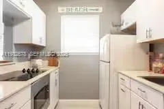 a kitchen with a sink a refrigerator and cabinets