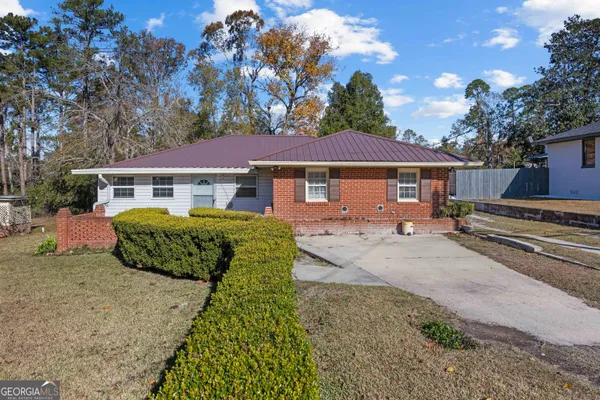 a front view of a house with a garden and trees