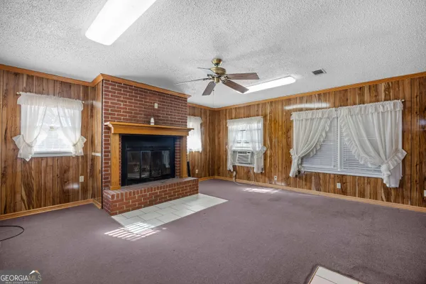 a view of empty room with fireplace and windows
