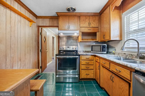 a kitchen with stainless steel appliances granite countertop a sink a stove and island