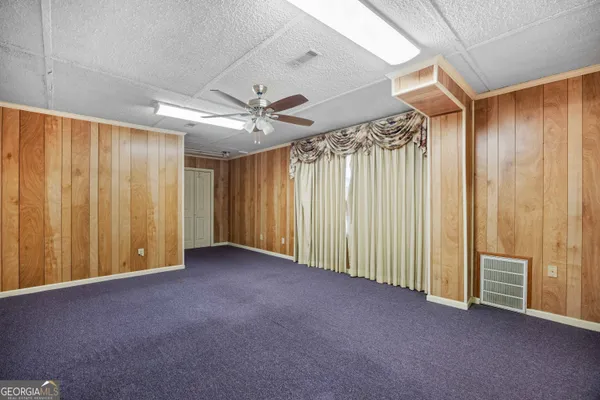 a view of empty room with window and wooden floor
