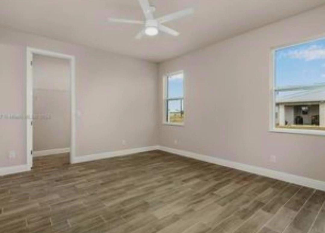 321 Neighborly Road LaBelle, FL 33935 - Photo 13 of 18 an empty room with wooden floor and windows