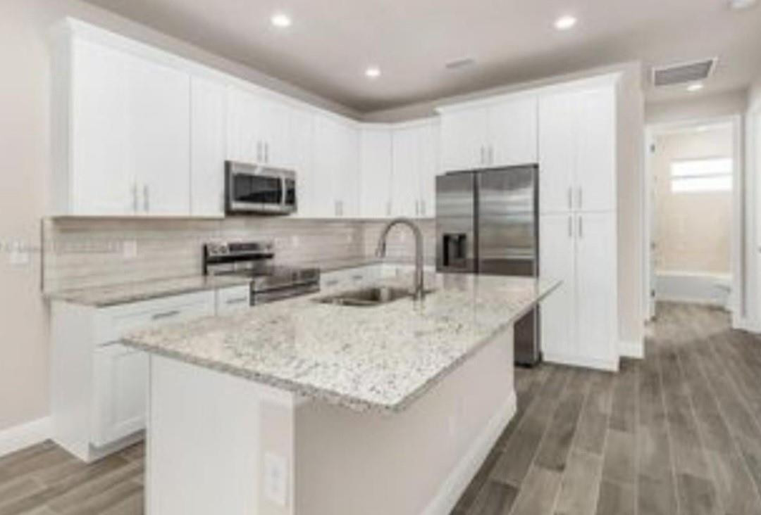 321 Neighborly Road LaBelle, FL 33935 - Photo 3 of 18 a kitchen with stainless steel appliances granite countertop a sink stove and refrigerator