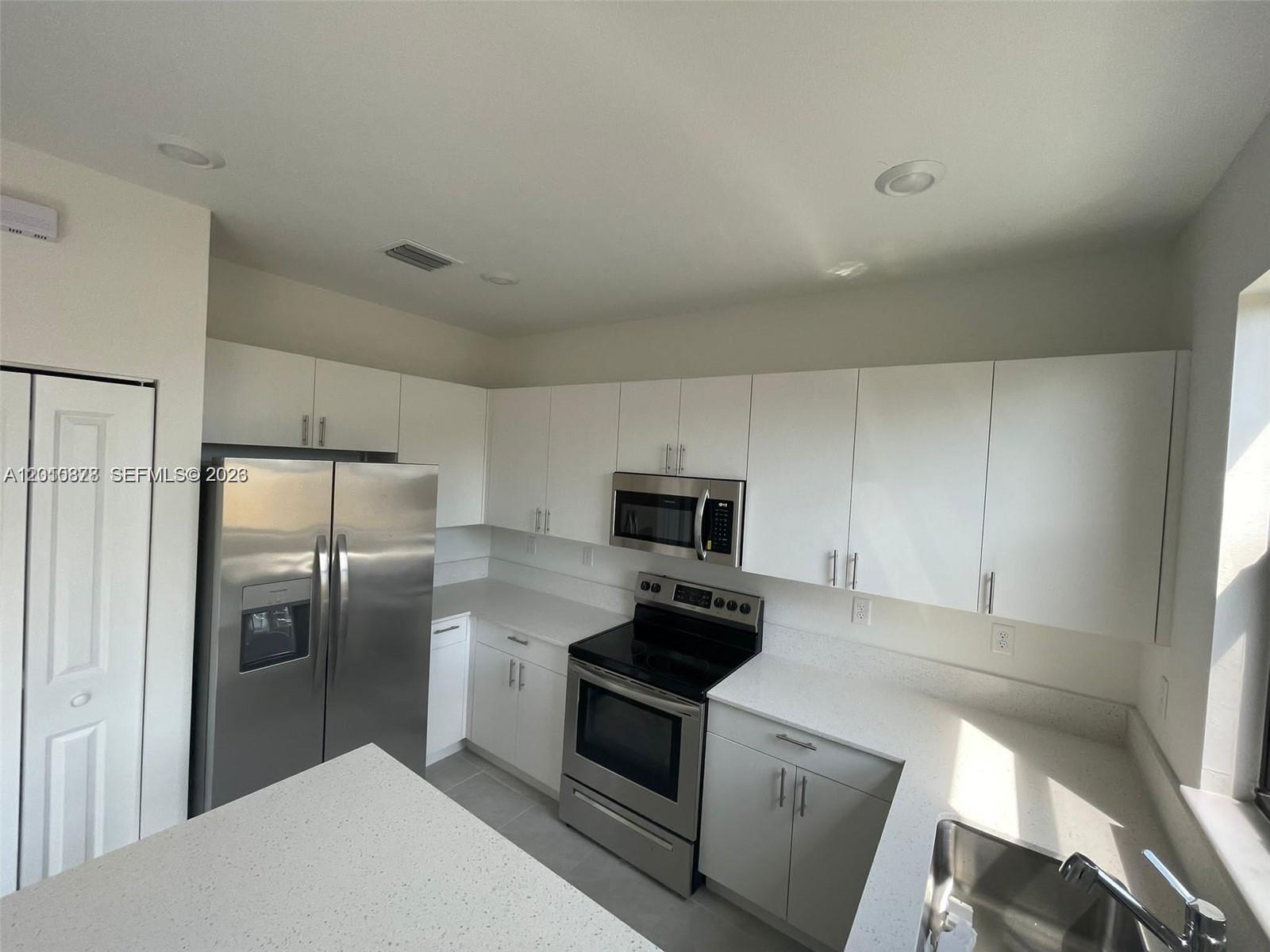 24641 Southwest 117th Path, Unit 24641 Homestead, FL 33032 - Photo 5 of 9 a kitchen with cabinets and stainless steel appliances