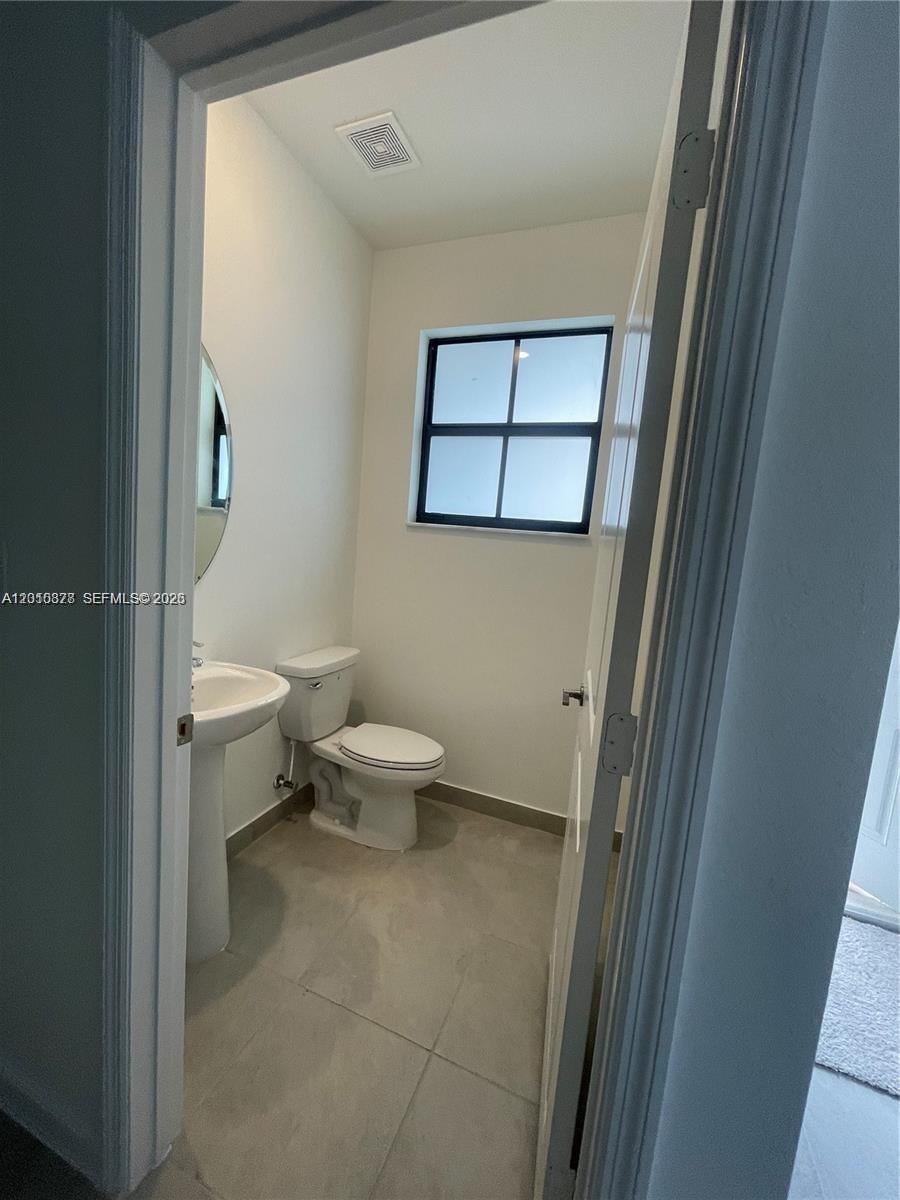 24641 Southwest 117th Path, Unit 24641 Homestead, FL 33032 - Photo 6 of 9 a white toilet sitting next to a white sink