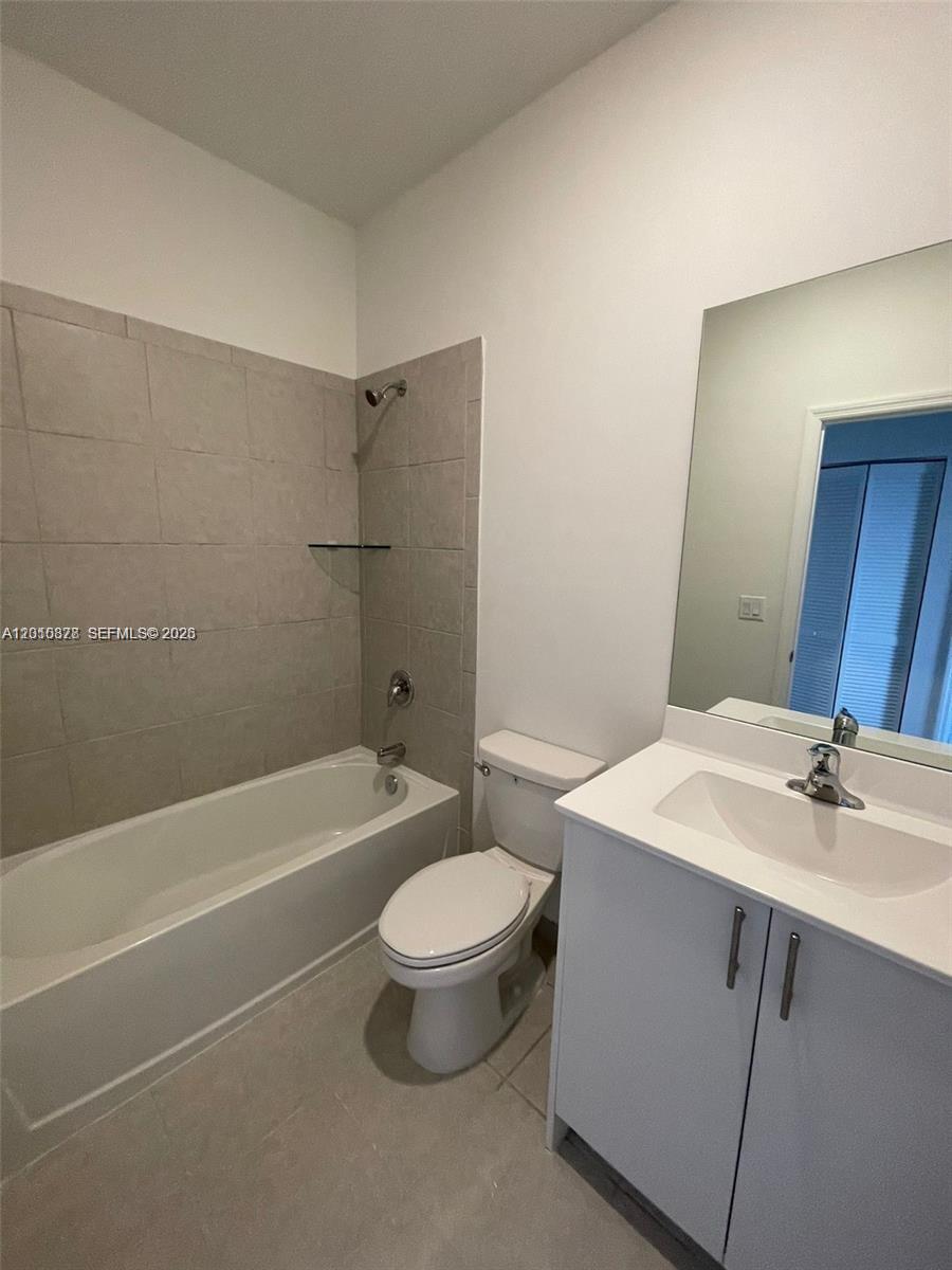 24641 Southwest 117th Path, Unit 24641 Homestead, FL 33032 - Photo 7 of 9 a bathroom with a sink a toilet and a bathtub