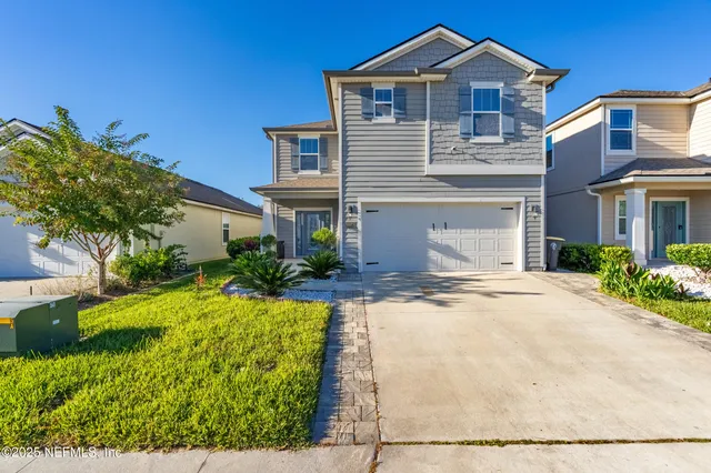 a kitchen with stainless steel appliances a sink a stove a refrigerator cabinets and a dining table