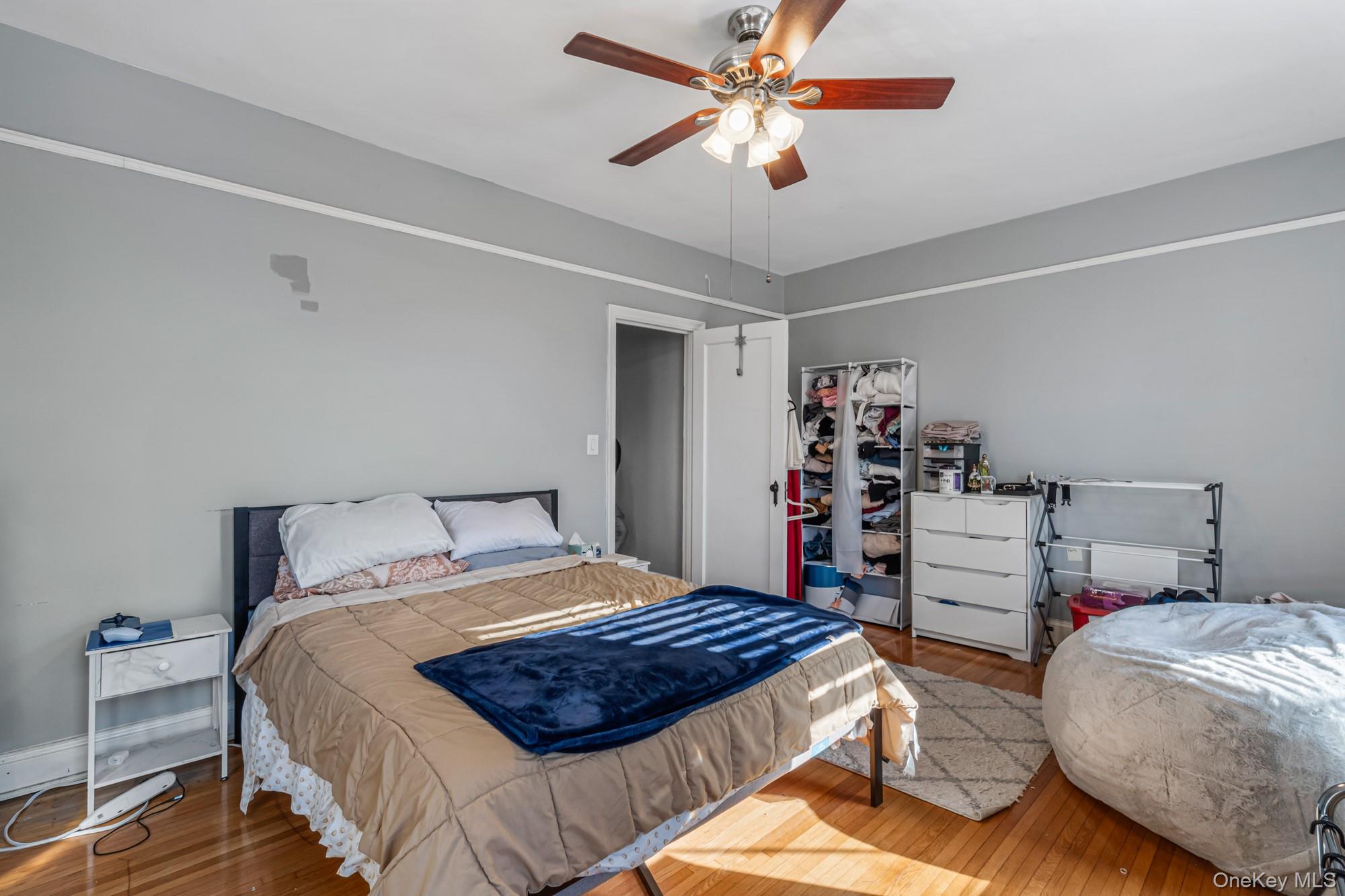 45 Kew Gardens Road, Unit 4A Queens, NY 11415 - Photo 12 of 19 a bedroom with a bed and a chandelier