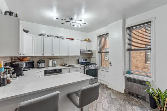 a kitchen with cabinets appliances a sink and a counter top space