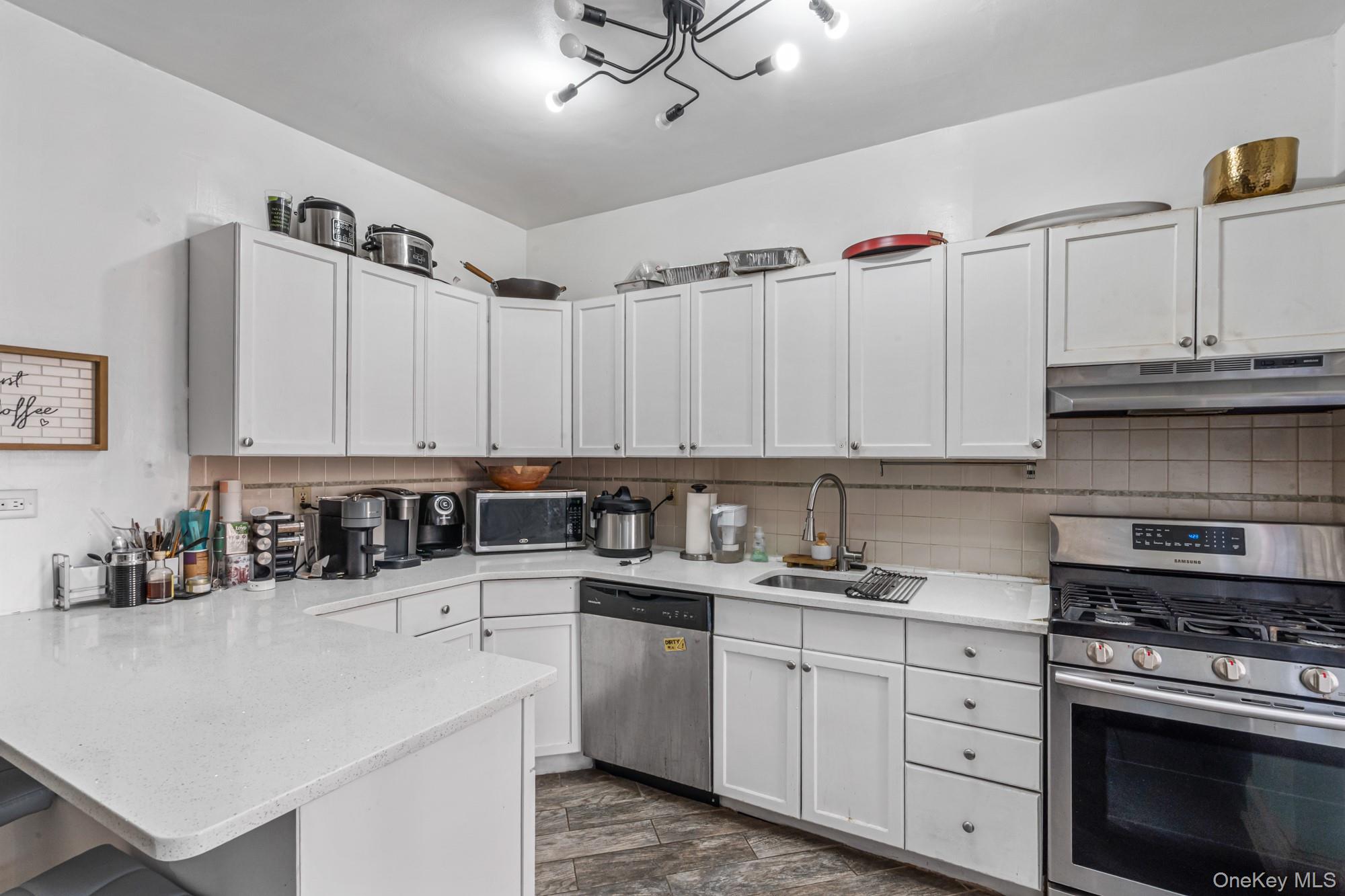 45 Kew Gardens Road, Unit 4A Queens, NY 11415 - Photo 9 of 19 a kitchen with cabinets appliances a sink and a counter top space