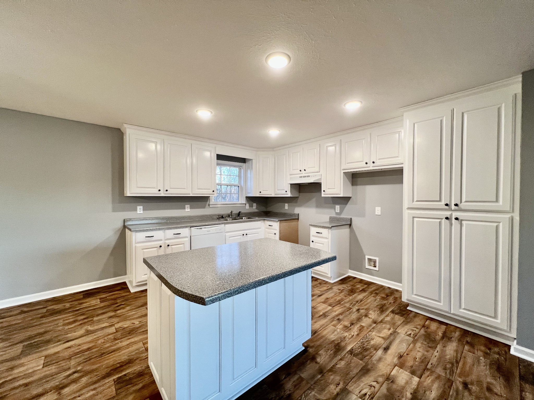 2379 Franklin Hayes Road Pulaski, TN 38478 - Photo 4 of 19 a kitchen with kitchen island granite countertop a refrigerator a sink dishwasher and white cabinets with wooden floor