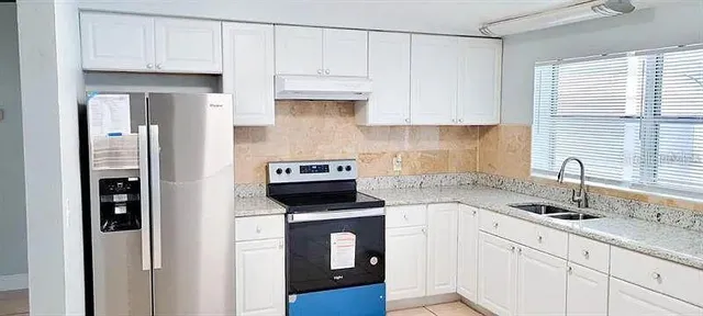 a kitchen with white cabinets and white appliances