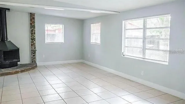 a view of empty room with window and fireplace