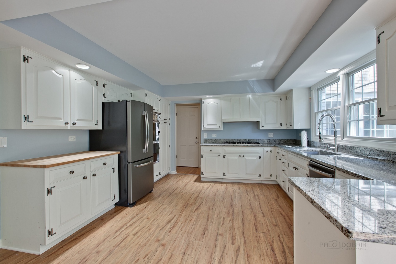 13 Forest Hills Road Lake Bluff, IL 60044 - Photo 11 of 24 a kitchen with granite countertop a refrigerator oven a sink dishwasher and white cabinets with wooden floor