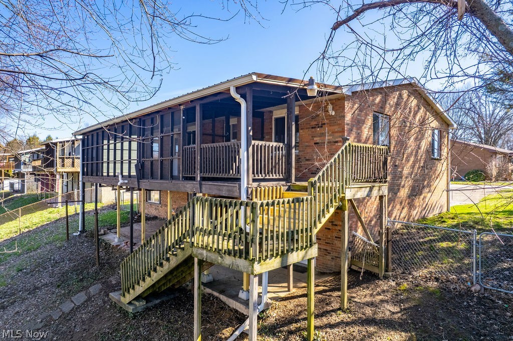 3601 River Road Vienna, WV 26105 - Photo 39 of 40 Rear view of house with a sunroom, a wooden deck, a gate, and brick siding