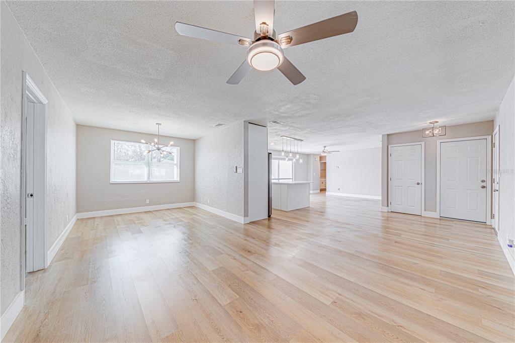 1648 Caldwell Road Daytona Beach, FL 32119 - Photo 15 of 45 an empty room with wooden floor chandelier fan and windows