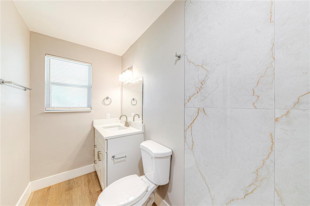 1648 Caldwell Road Daytona Beach, FL 32119 - Photo 29 of 45 a white toilet sitting next to a bathroom sink and vanity