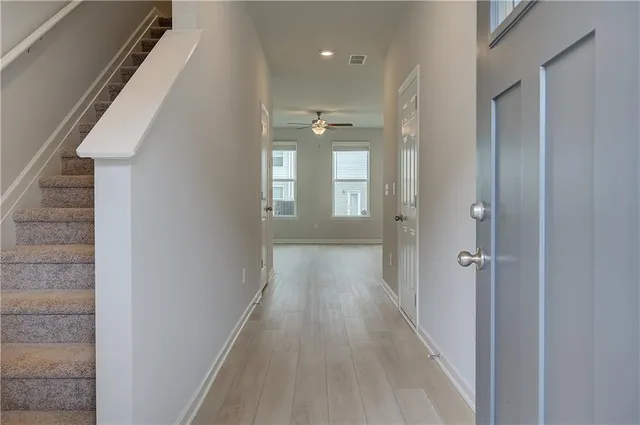 a view of a hallway with wooden floor and staircase