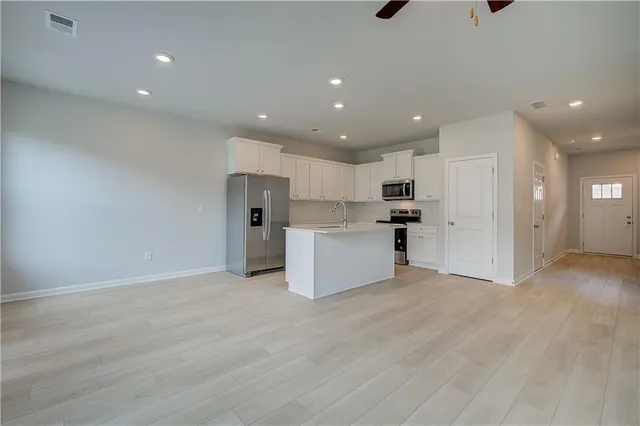 a view of a kitchen with refrigerator and wooden floor