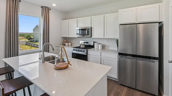 a kitchen with refrigerator and white table chairs
