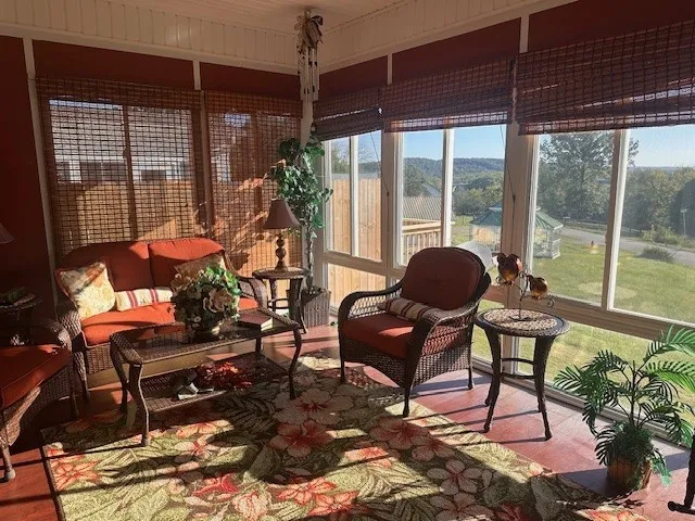 a living room with furniture a couch and large windows