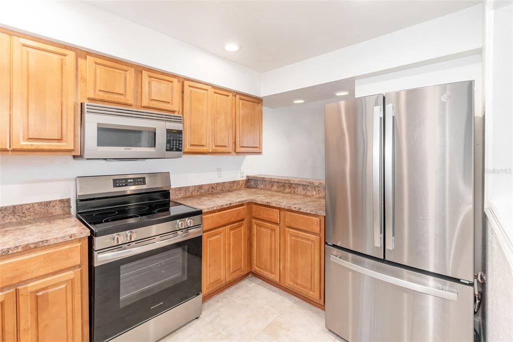 940 Douglas Avenue, Unit 175 Altamonte Springs, FL 32714 - Photo 14 of 44 a kitchen with granite countertop a refrigerator stove and microwave