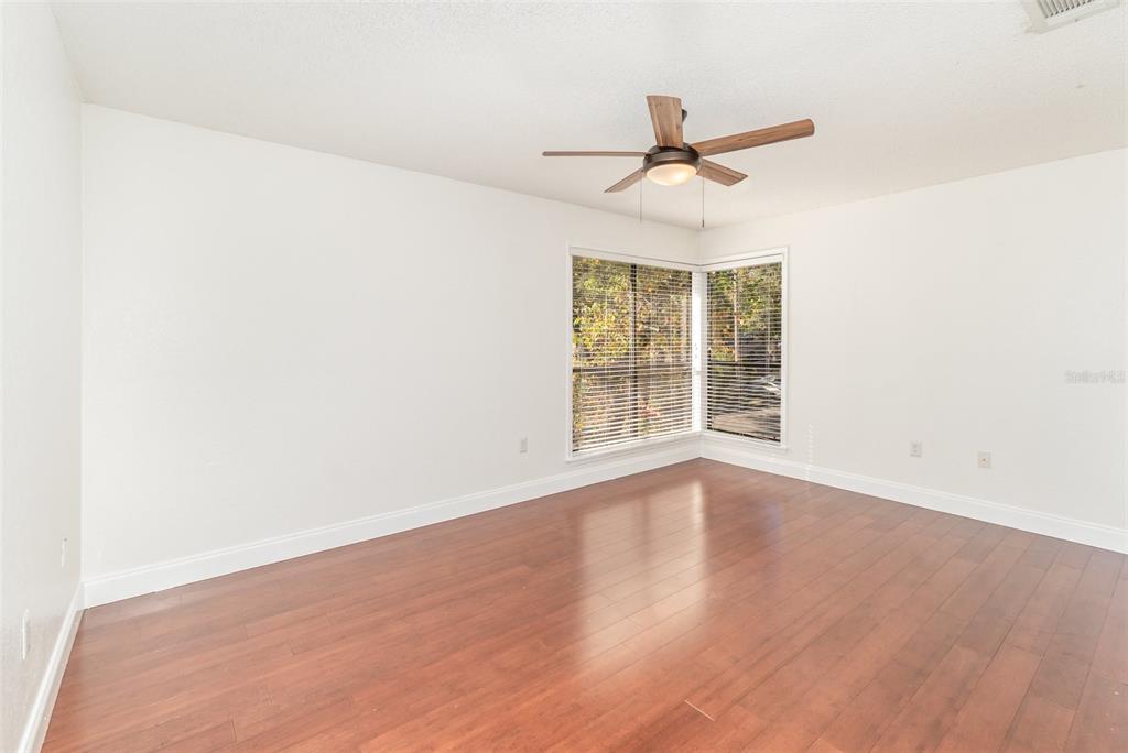 940 Douglas Avenue, Unit 175 Altamonte Springs, FL 32714 - Photo 19 of 44 an empty room with wooden floor fan and windows
