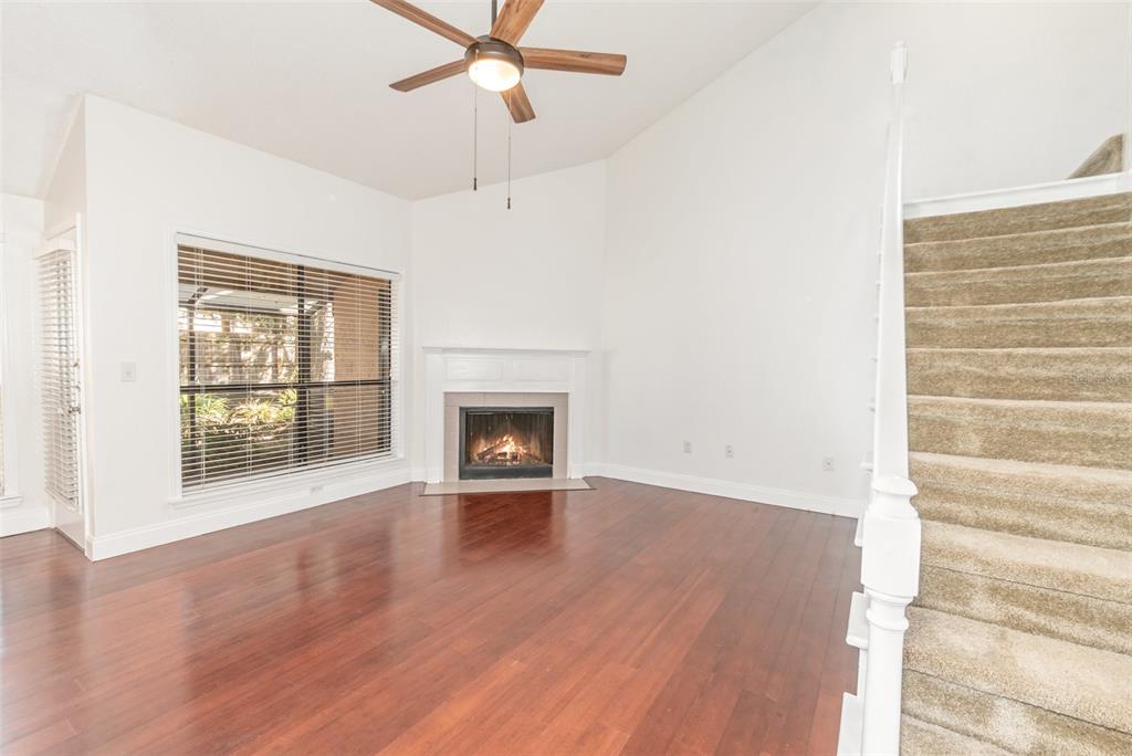 940 Douglas Avenue, Unit 175 Altamonte Springs, FL 32714 - Photo 7 of 44 an empty room with wooden floor a ceiling fan and windows