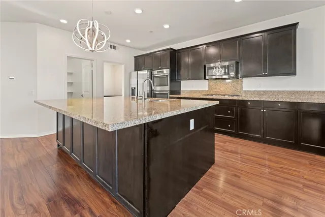 a kitchen with stainless steel appliances granite countertop a sink stove and wooden floor