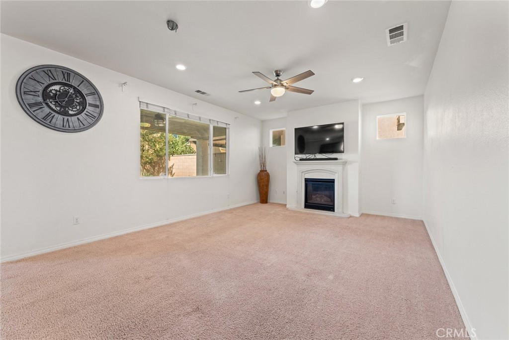 8022-8022 Sea Salt Avenue Fontana, CA 92336 - Photo 14 of 35 a view of a livingroom with a fireplace a flat screen tv and a ceiling fan