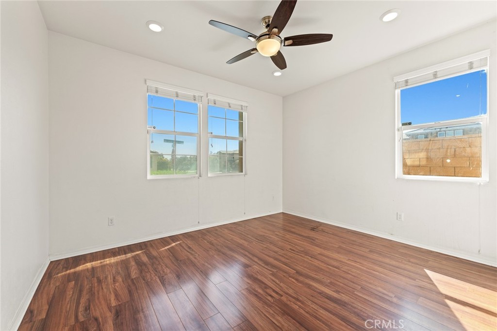8022-8022 Sea Salt Avenue Fontana, CA 92336 - Photo 7 of 35 a view of empty room with wooden floor and fan