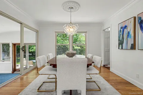 a living room with furniture a dining table and a large window