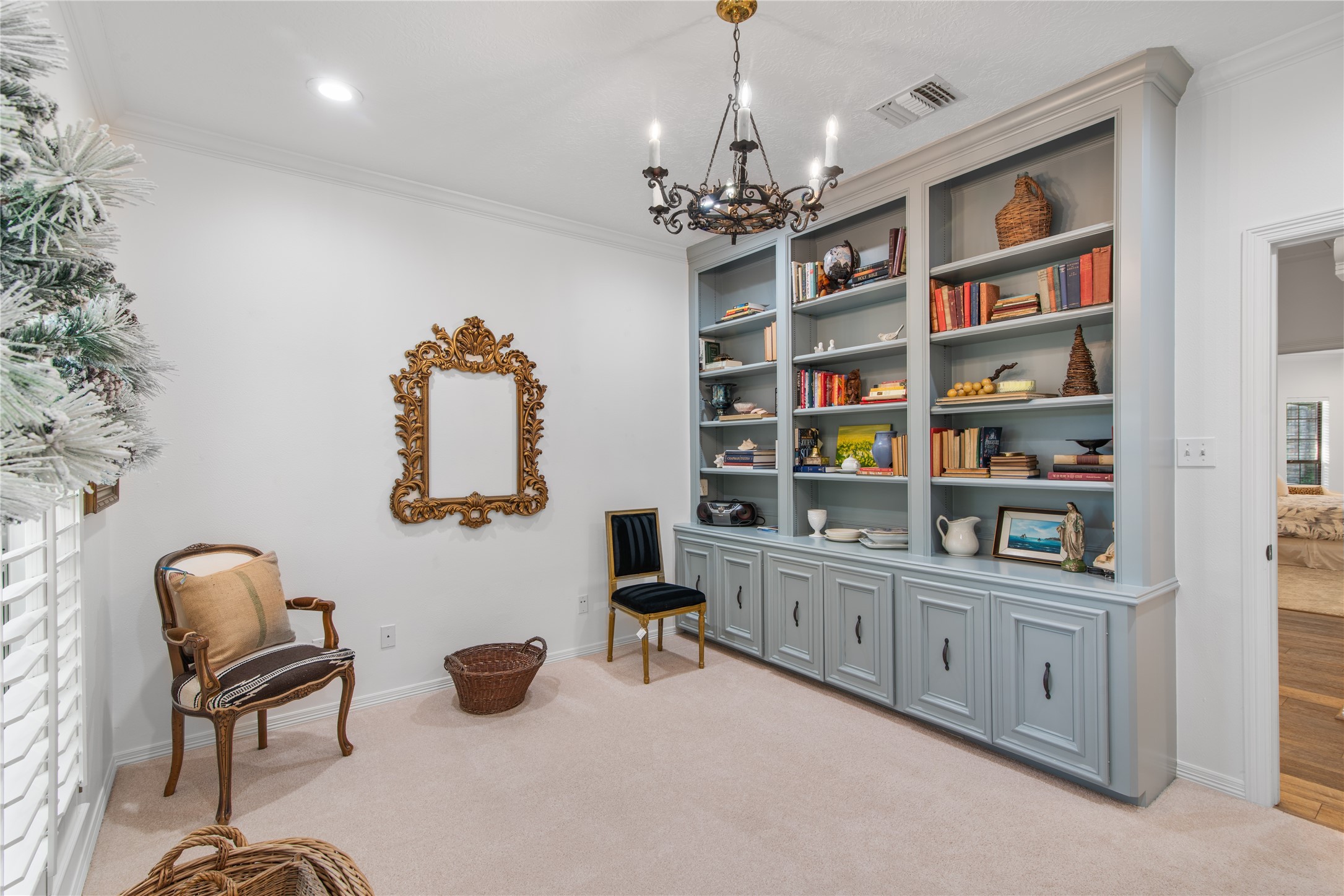 901 Longmire Road, Unit 51 Conroe, TX 77304 - Photo 33 of 48 Beautiful and practical with built-in shelves and cabinetry, featuring a decorative mirror and classic chandelier, creating a cozy reading or sitting area.