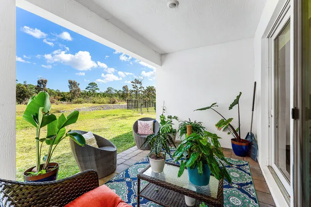 a view of a porch with furniture and a yard