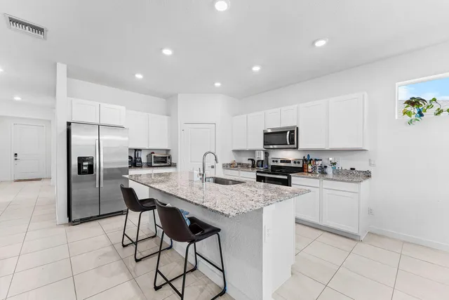 a kitchen with stainless steel appliances granite countertop a sink and a refrigerator