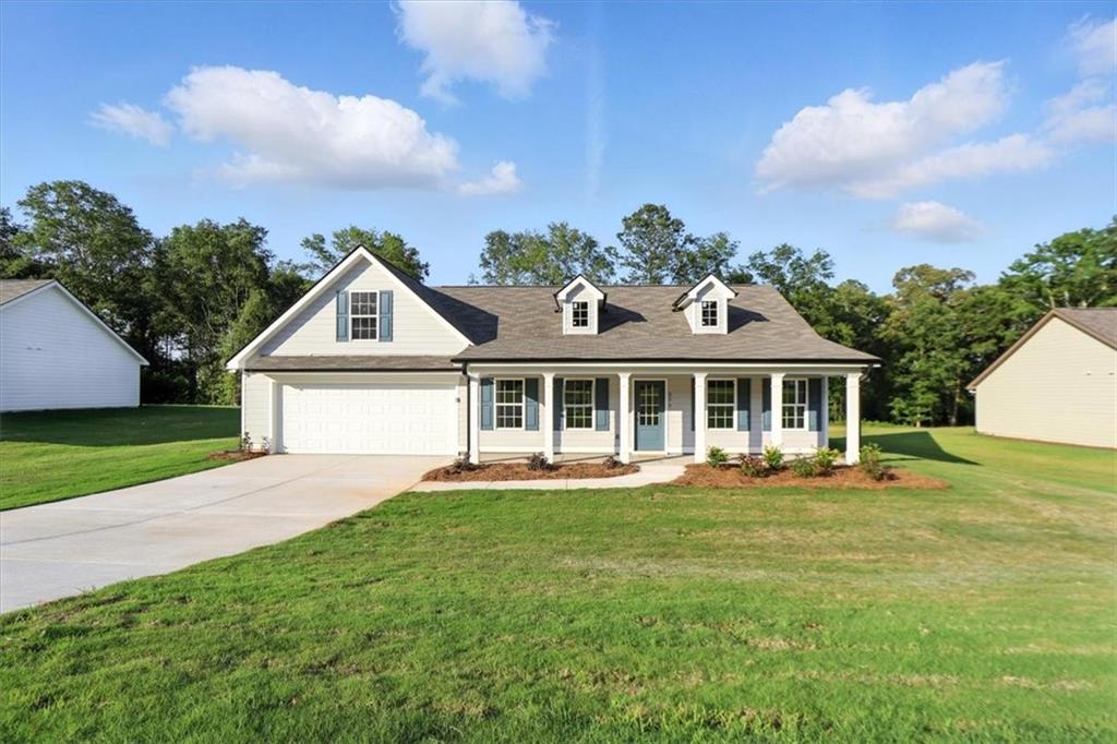 a front view of a house with a garden and trees