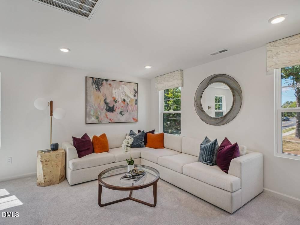 3101 White Blossom Court, Unit SAVANNAH 3109 Raleigh, NC 27610 - Photo 17 of 20 a living room with furniture and a mirror