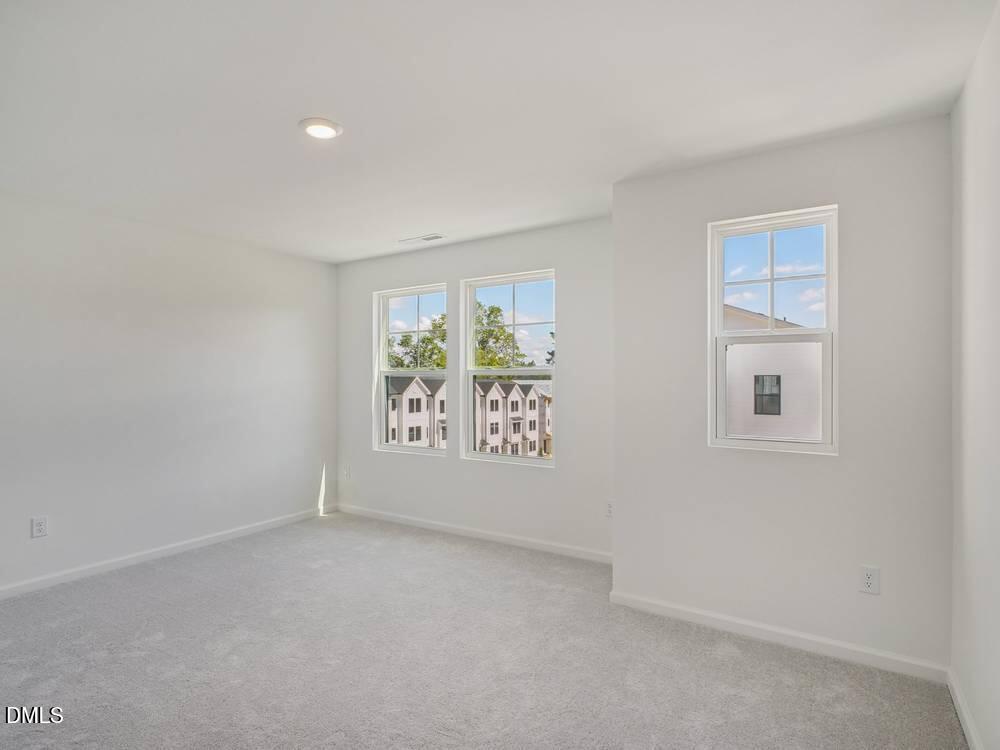 3101 White Blossom Court, Unit SAVANNAH 3109 Raleigh, NC 27610 - Photo 18 of 20 an empty room with windows