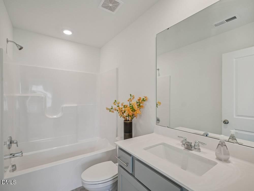 3101 White Blossom Court, Unit SAVANNAH 3109 Raleigh, NC 27610 - Photo 19 of 20 a bathroom with a sink toilet and shower