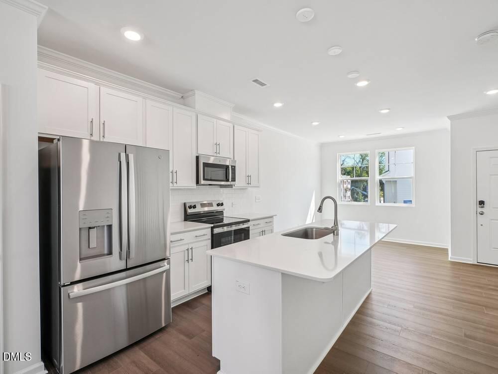 3101 White Blossom Court, Unit SAVANNAH 3109 Raleigh, NC 27610 - Photo 6 of 20 a kitchen with stainless steel appliances a refrigerator sink and microwave