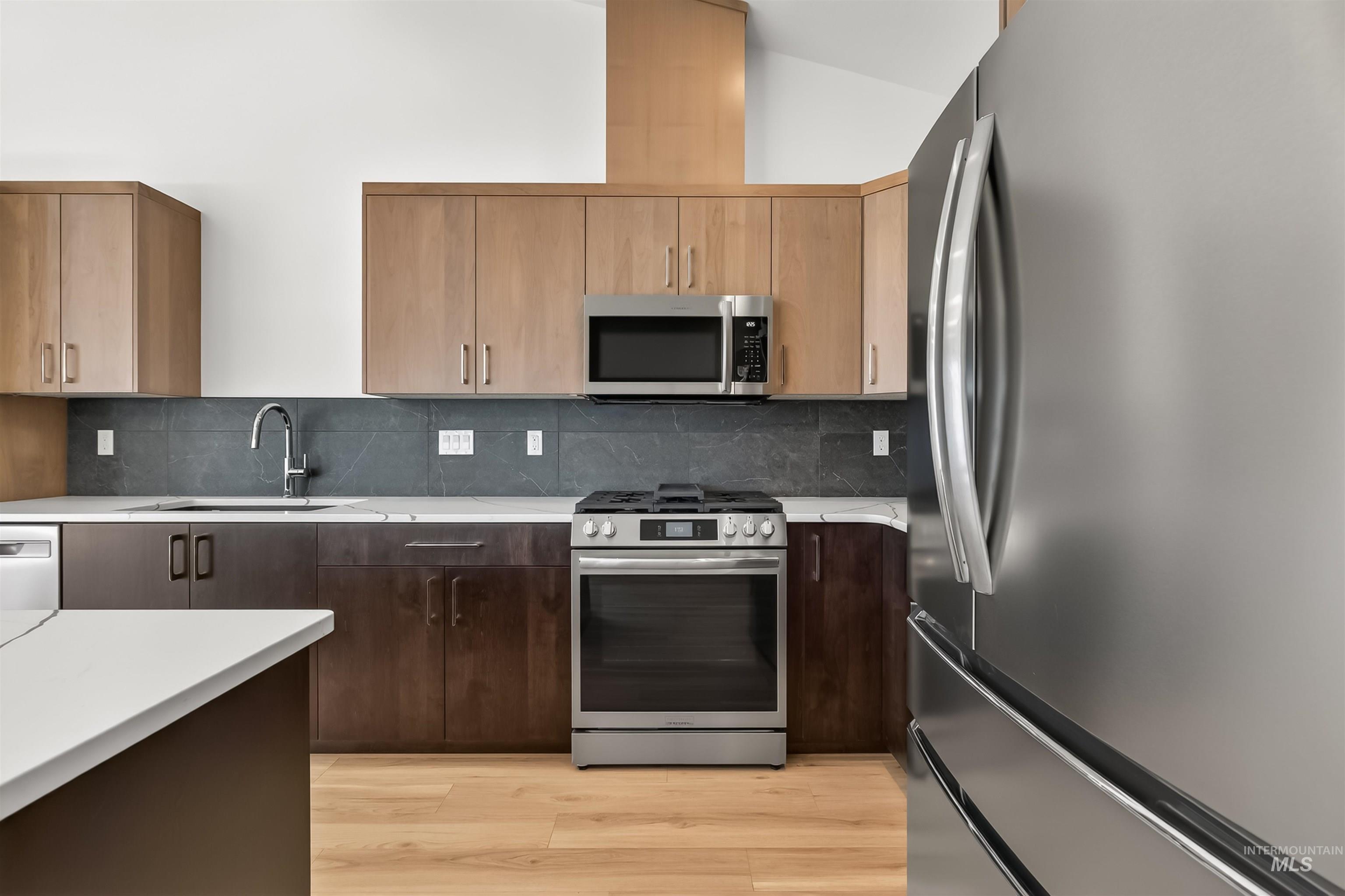 3710 22nd Street Lewiston, ID 83501 - Photo 17 of 36 Kitchen with stainless steel appliances, light wood-type flooring, light stone countertops, and tasteful backsplash