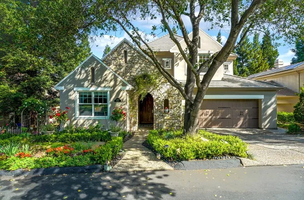 a front view of a house with a yard and potted plants